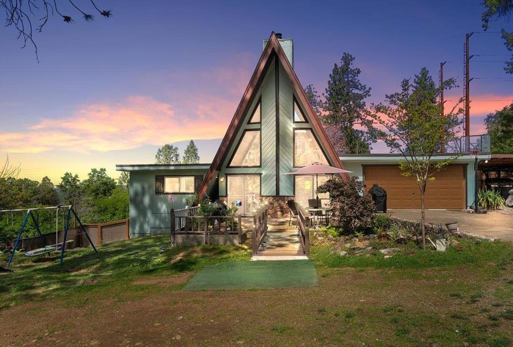 a view of backyard of house with outdoor seating and green space