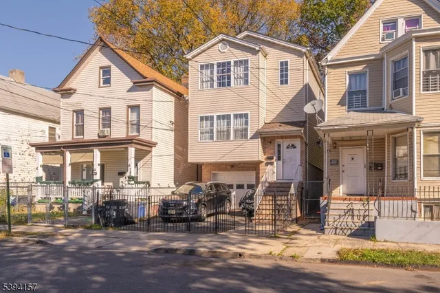 a view of a white house with large windows and a table and chairs