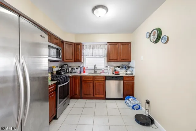 a kitchen with stainless steel appliances granite countertop a refrigerator and a stove top oven