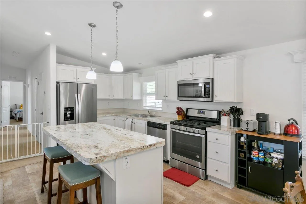 9100 Single Oak Drive Lakeside, CA 92040 - Photo 13 of 28 a kitchen with granite countertop a stove a sink and a refrigerator