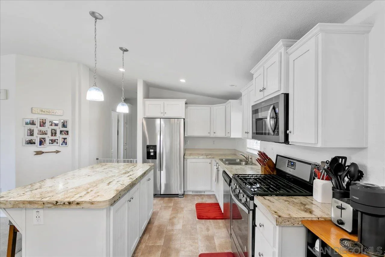 9100 Single Oak Drive Lakeside, CA 92040 - Photo 14 of 28 a kitchen with stainless steel appliances kitchen island granite countertop a sink stove and refrigerator