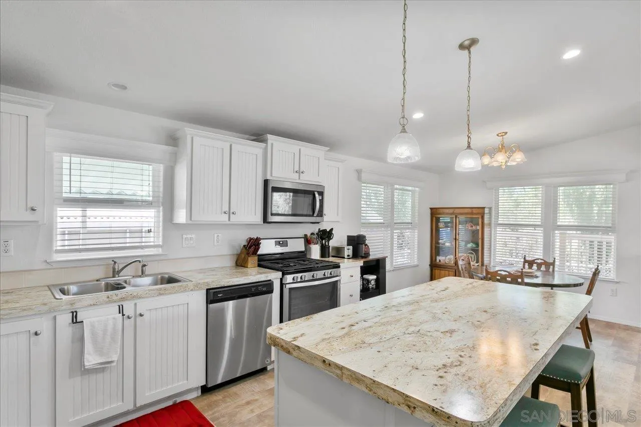 9100 Single Oak Drive Lakeside, CA 92040 - Photo 15 of 28 a kitchen with stainless steel appliances kitchen island granite countertop a sink stove and refrigerator