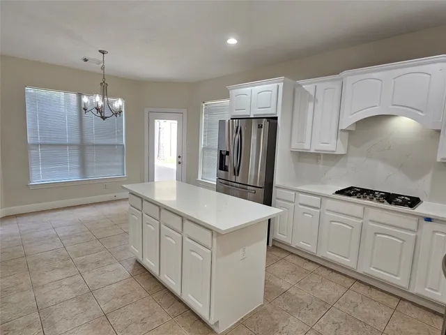 a kitchen that has a lot of cabinets in it and wooden floors