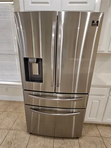 a kitchen with white cabinets and a stove with wooden floor