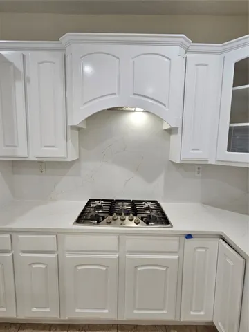 a large kitchen with kitchen island a refrigerator a stove a oven a dining table and chairs