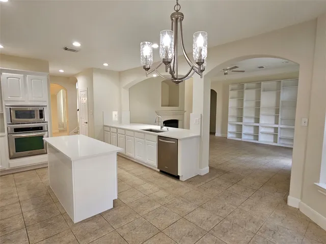 a kitchen with kitchen island granite countertop cabinets and stainless steel appliances