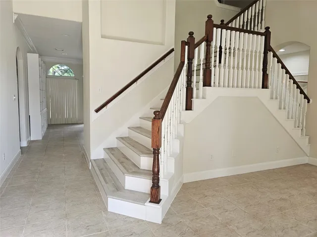 a view of staircase with railing and white walls