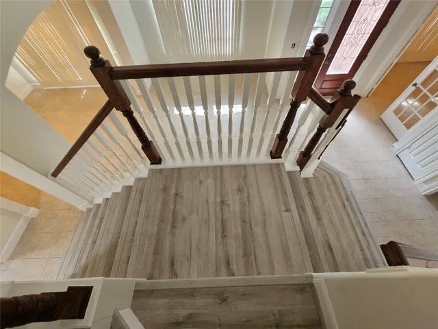 a view of staircase with railing and white walls