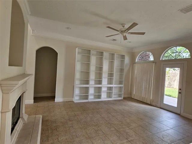 an empty room with a fireplace and windows