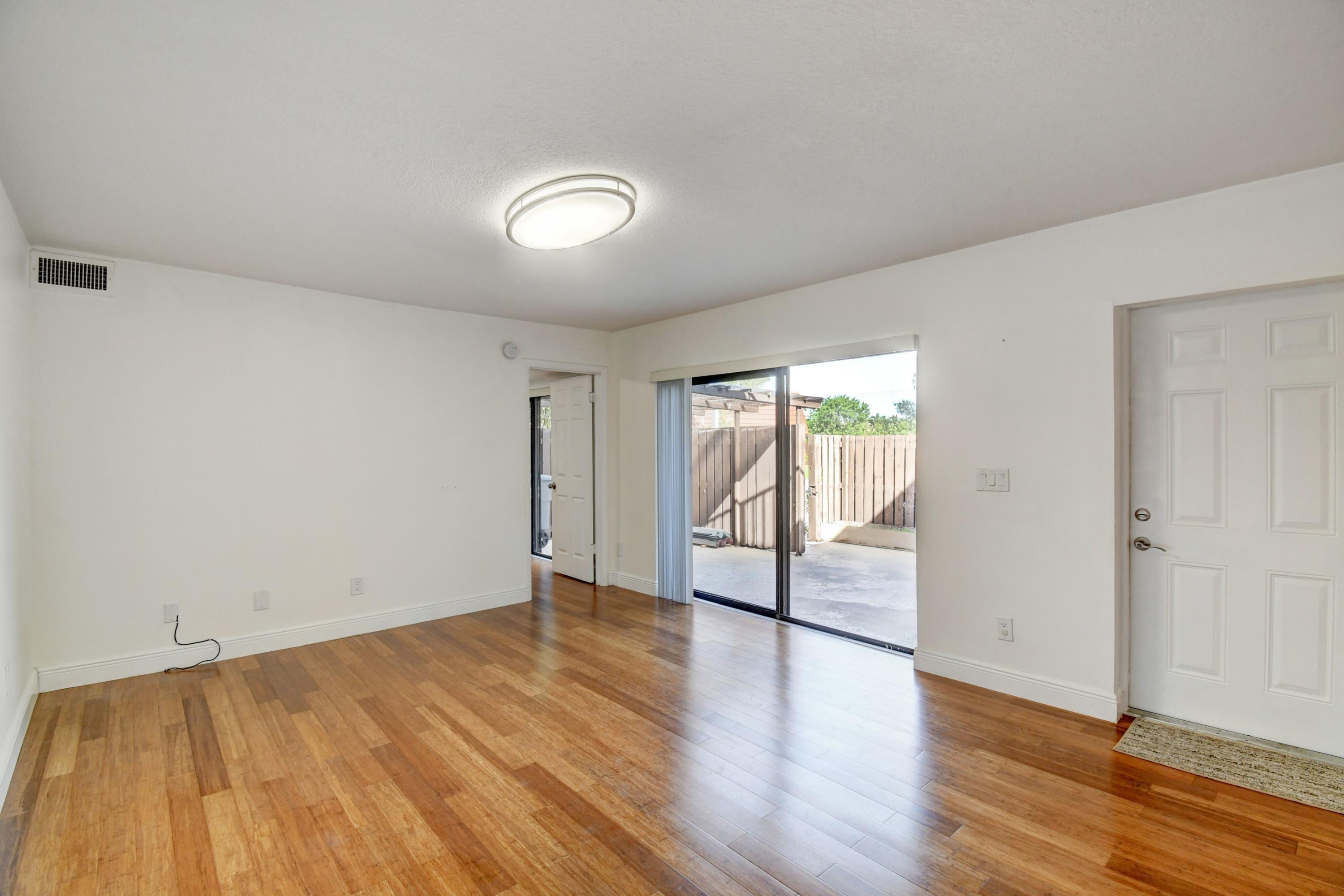 8253 Boca Rio Drive Boca Raton, FL 33433 - Photo 6 of 15 wooden floor in an empty room with a window