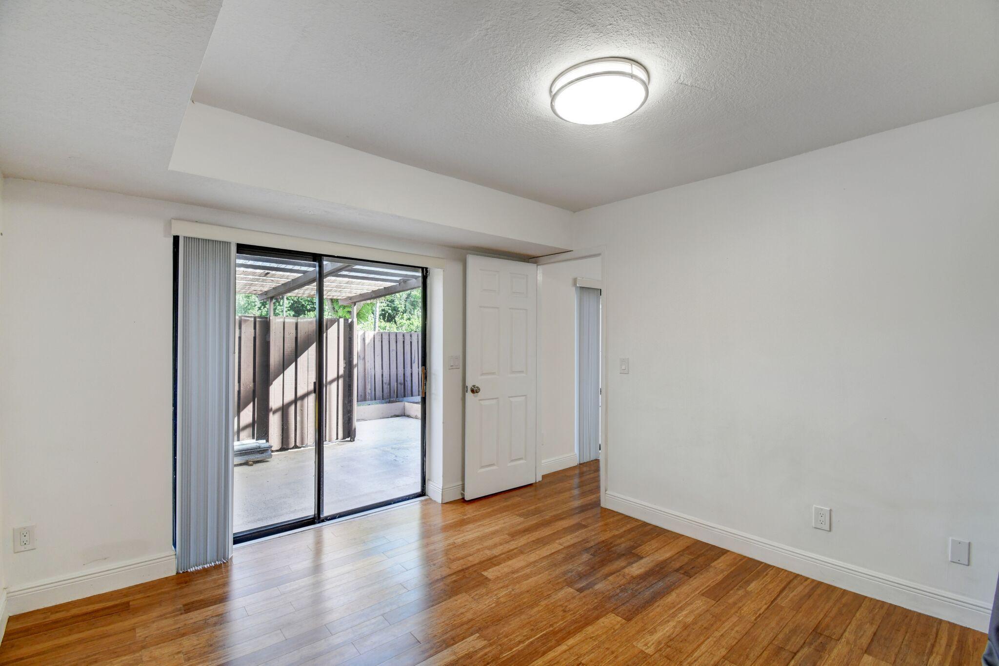 8253 Boca Rio Drive Boca Raton, FL 33433 - Photo 7 of 15 an empty room with wooden floor and a window
