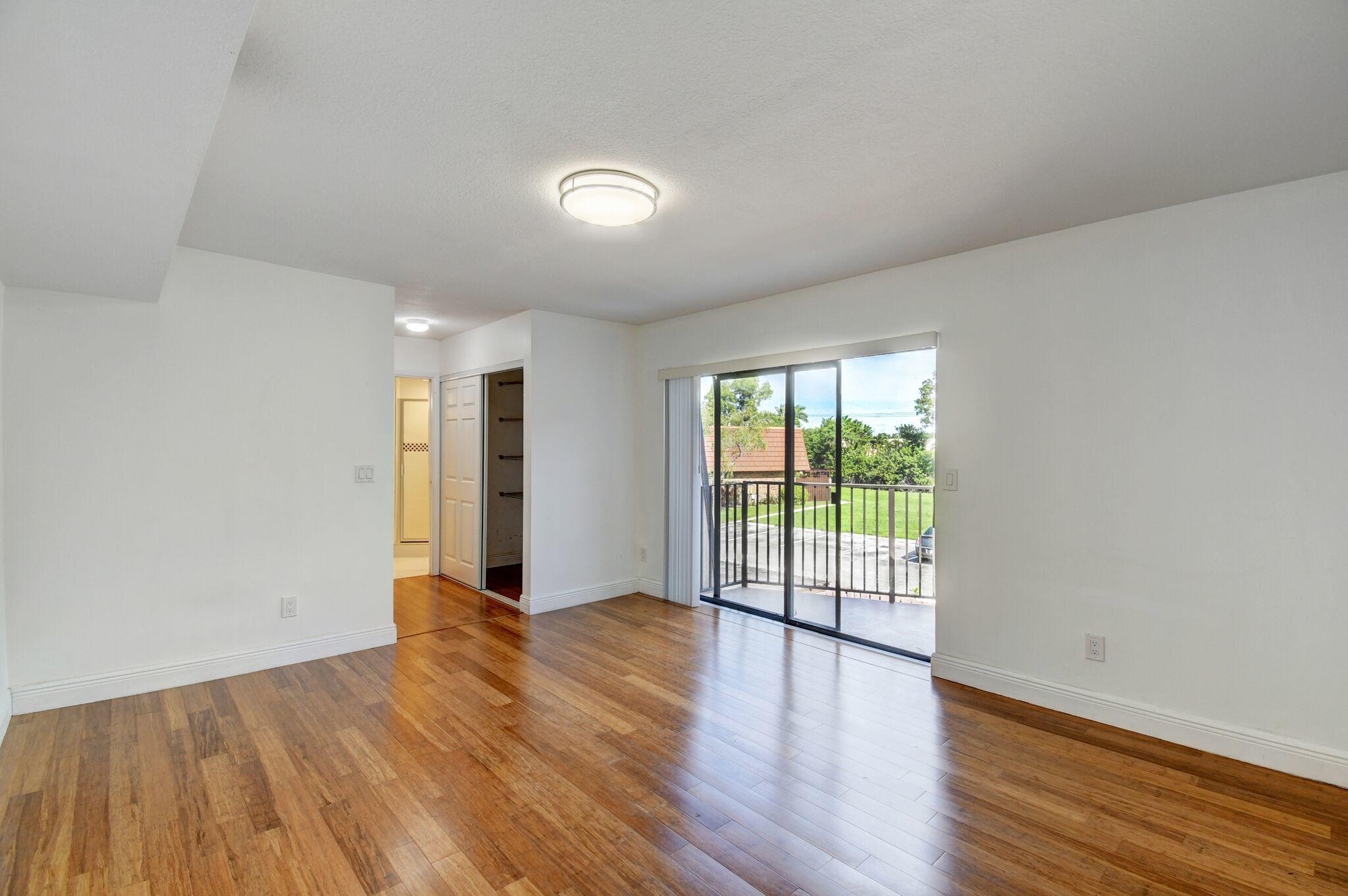 8253 Boca Rio Drive Boca Raton, FL 33433 - Photo 8 of 15 wooden floor in an empty room with a window