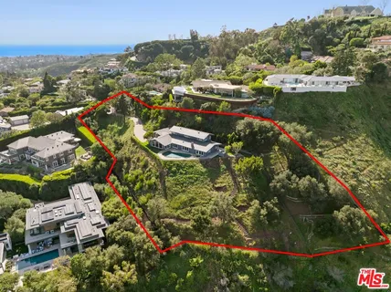 an aerial view of residential houses with outdoor space and trees