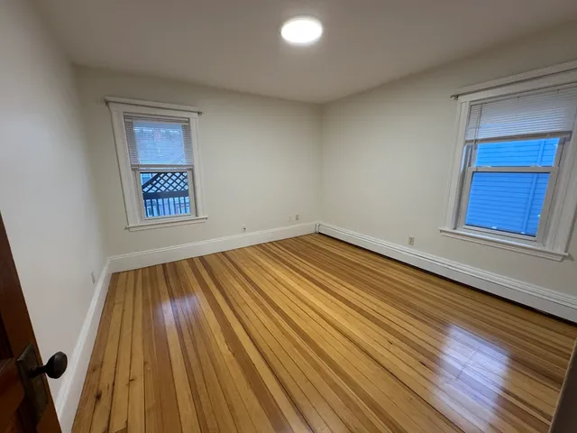 a view of a hallway with wooden floor and stairs