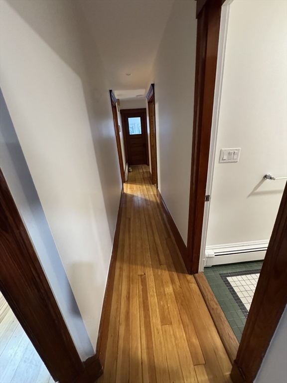 68 Aldrich Street, Unit 2 Boston, MA 02131 - Photo 6 of 12 a view of a hallway with wooden floor and stairs