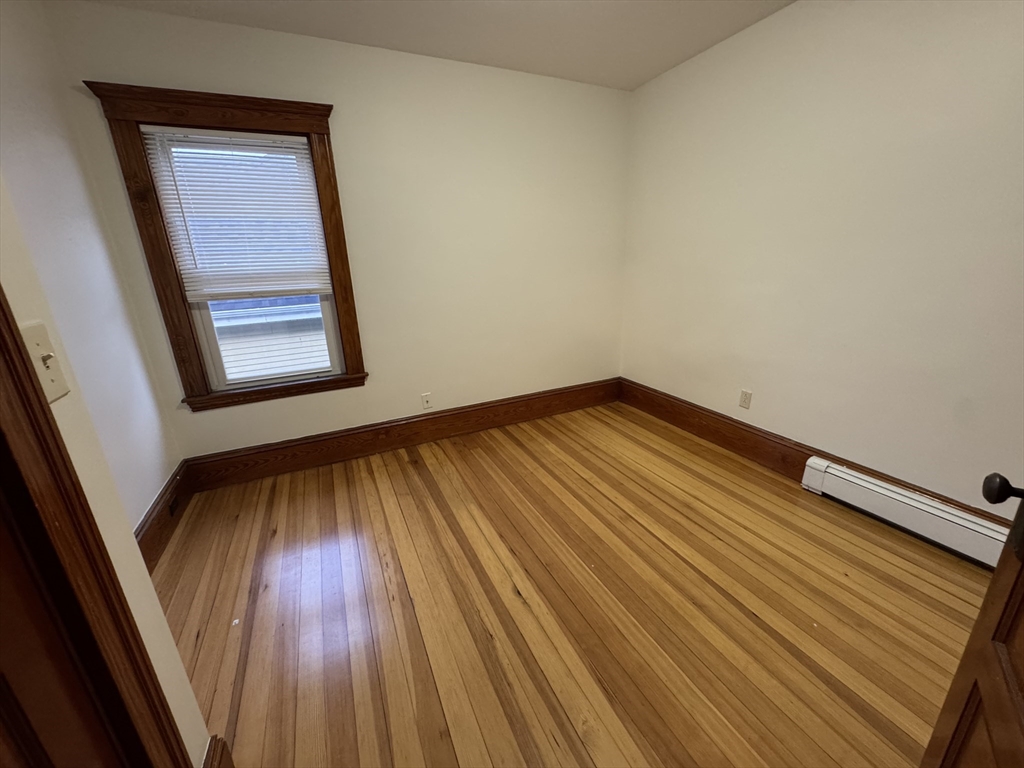 68 Aldrich Street, Unit 2 Boston, MA 02131 - Photo 7 of 12 a view of an empty room with wooden floor and a window
