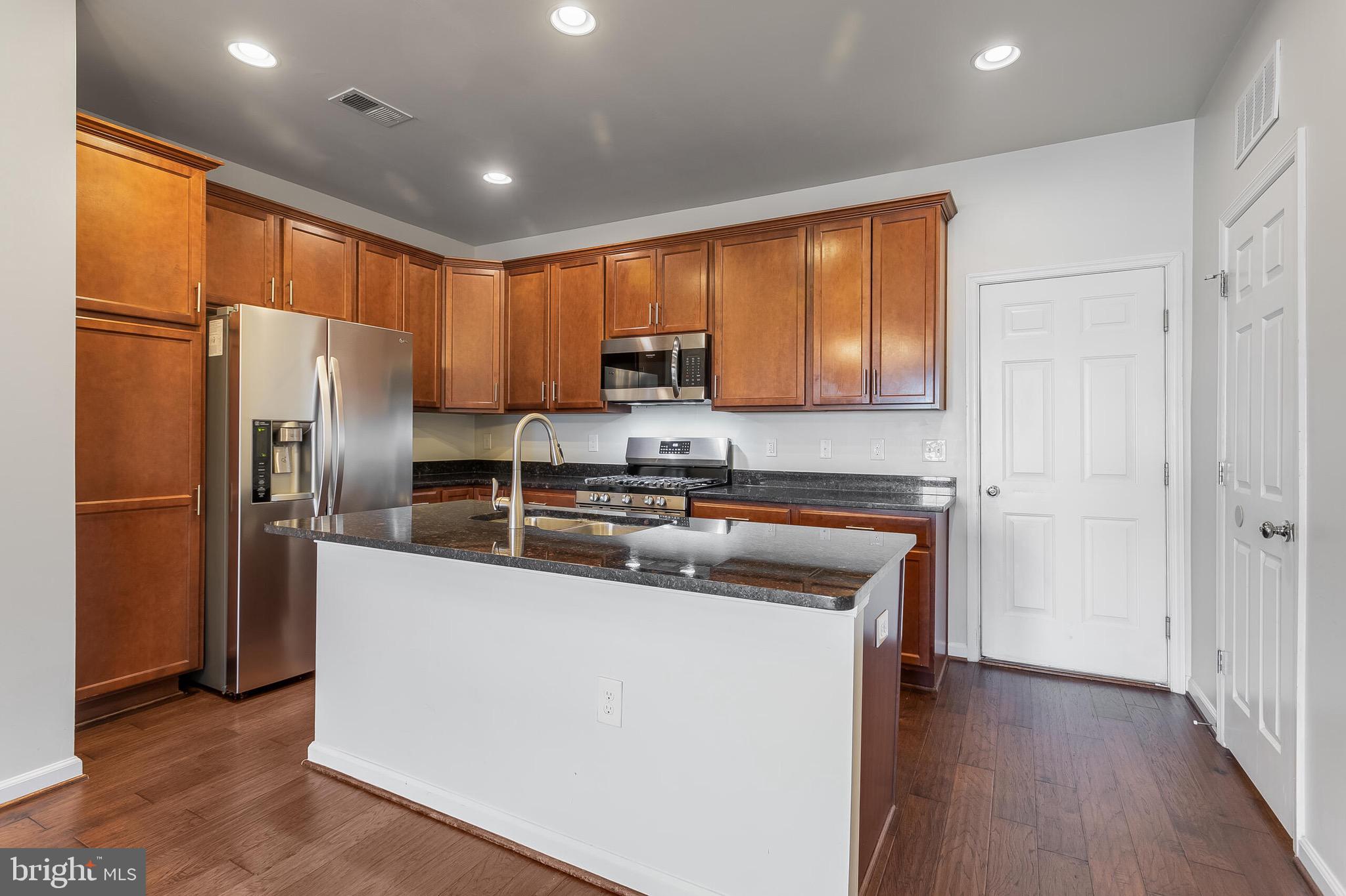 20586 Maitland Terrace Ashburn, VA 20147 - Photo 3 of 24 a kitchen with stainless steel appliances granite countertop a refrigerator a sink and a stove