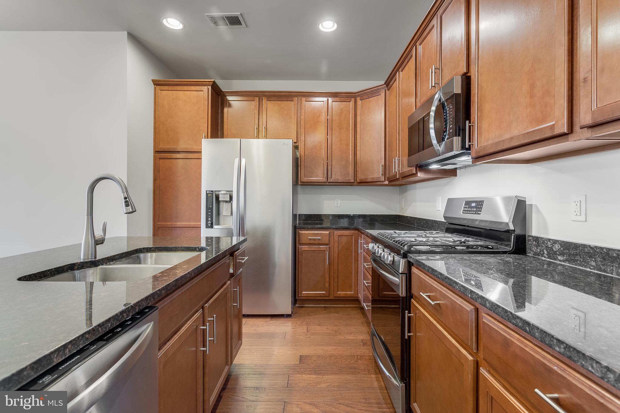 20586 Maitland Terrace Ashburn, VA 20147 - Photo 4 of 24 a kitchen with stainless steel appliances granite countertop a sink a stove and a refrigerator