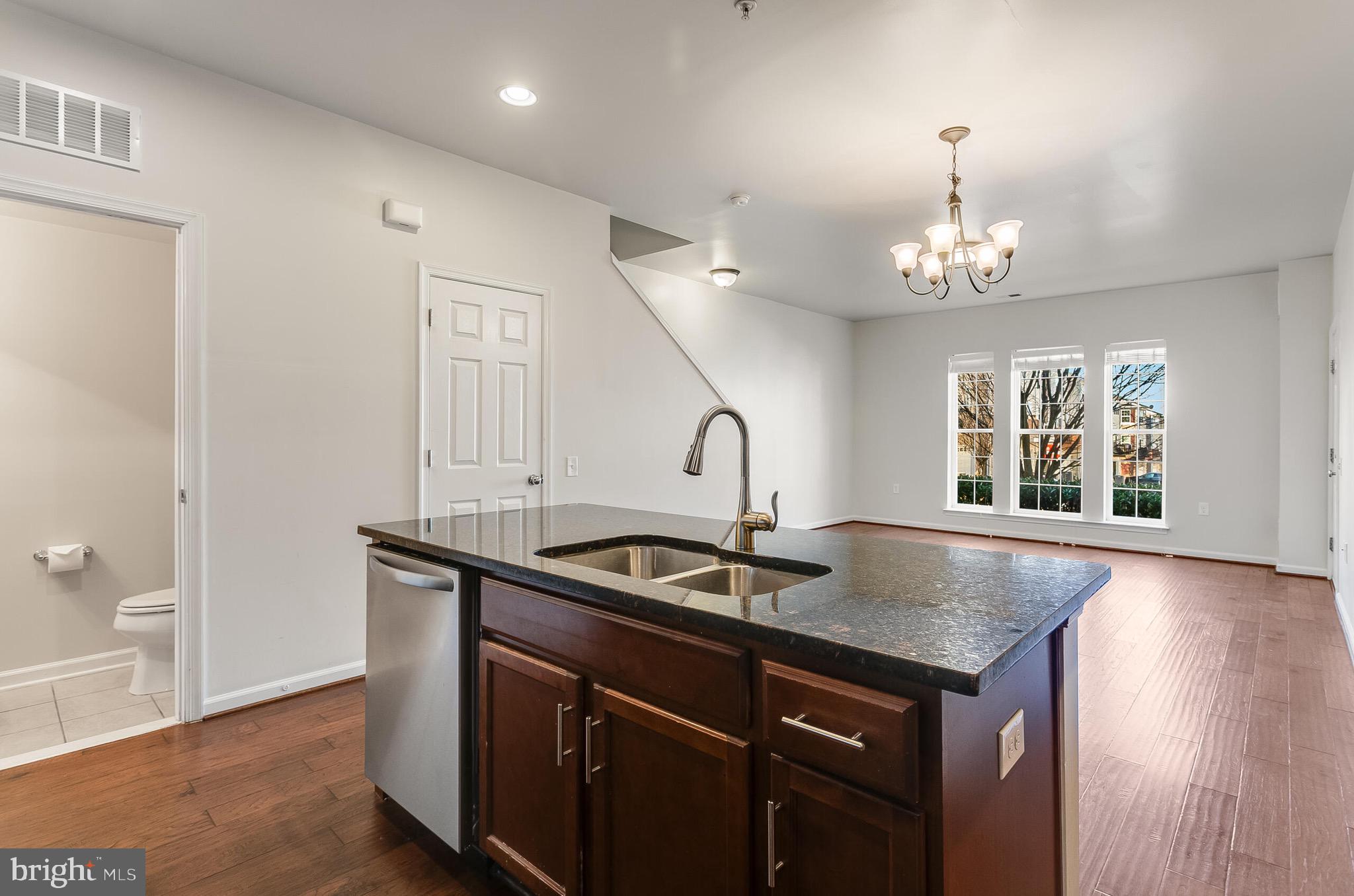 20586 Maitland Terrace Ashburn, VA 20147 - Photo 5 of 24 a view of a kitchen island a sink chandelier and wooden floor