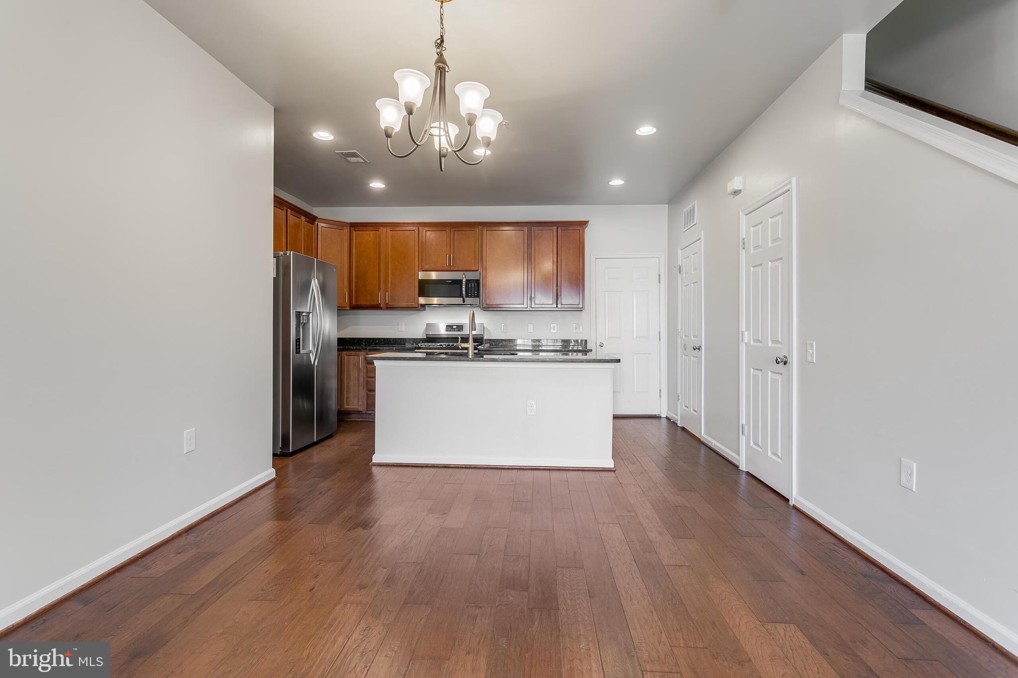 20586 Maitland Terrace Ashburn, VA 20147 - Photo 7 of 24 a large kitchen with stainless steel appliances granite countertop a large oven a refrigerator a sink and a stove with wooden floor