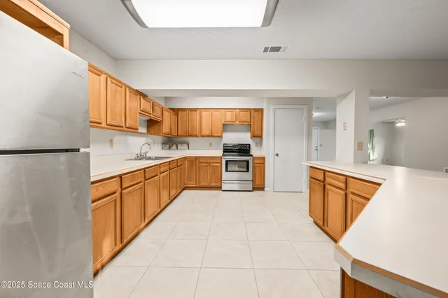 a large kitchen with stainless steel appliances cabinets a sink and a counter top space