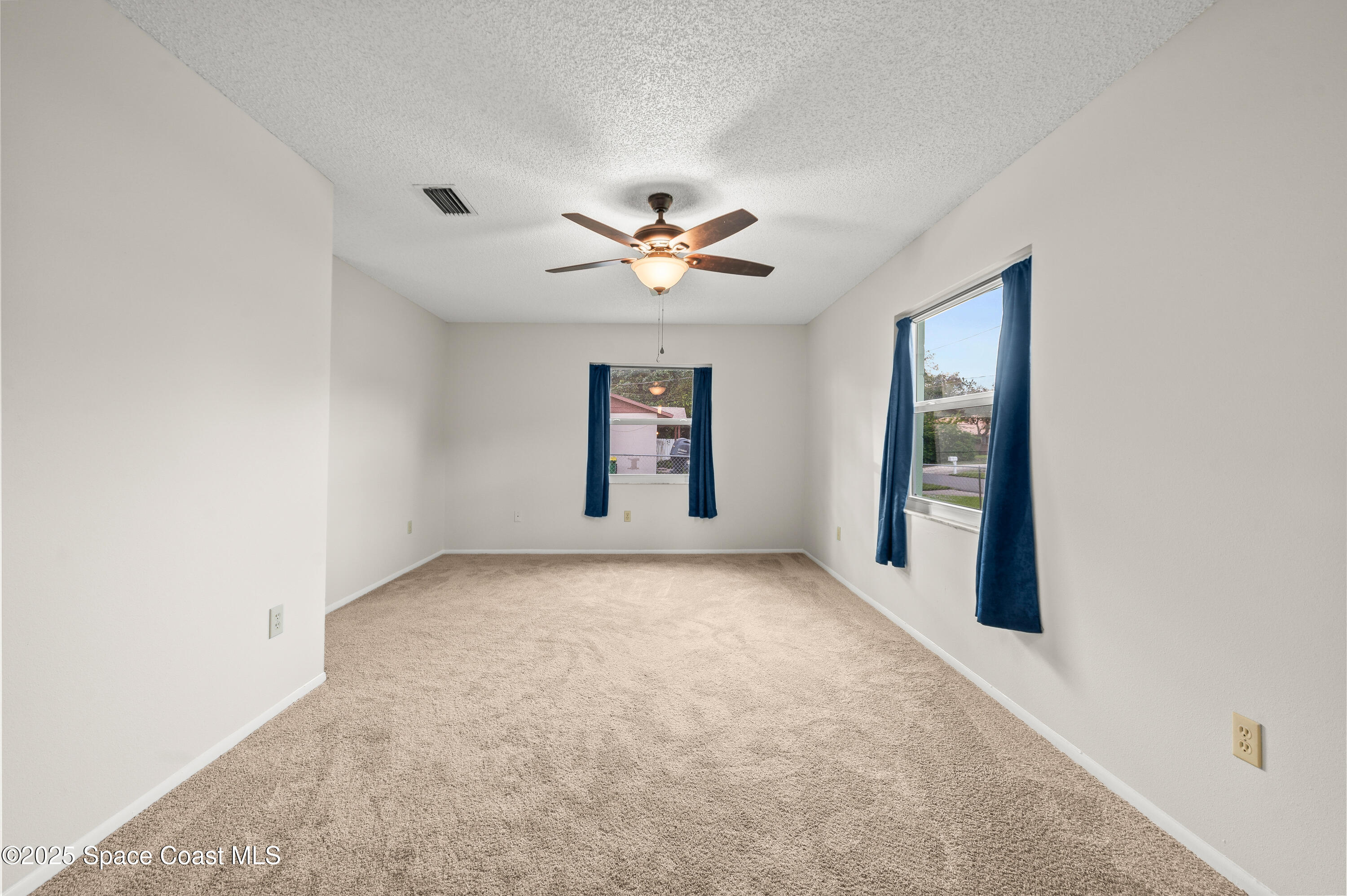 6450 Ember Avenue Cocoa, FL 32927 - Photo 17 of 40 an empty room with windows and ceiling fan