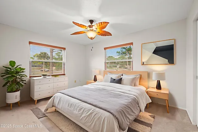 an empty room that has a window and a ceiling fan