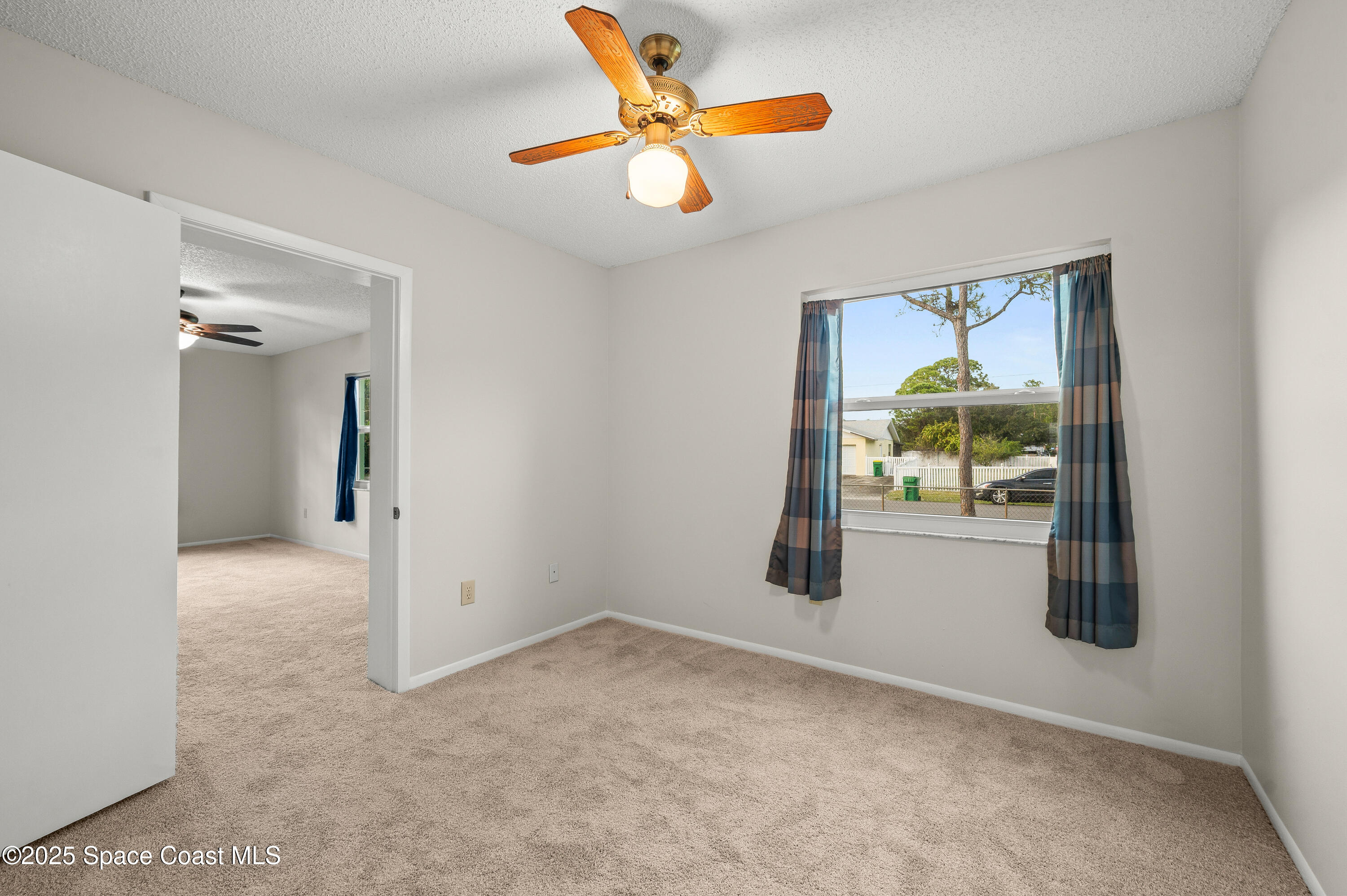 6450 Ember Avenue Cocoa, FL 32927 - Photo 23 of 40 an empty room that has a window and a ceiling fan