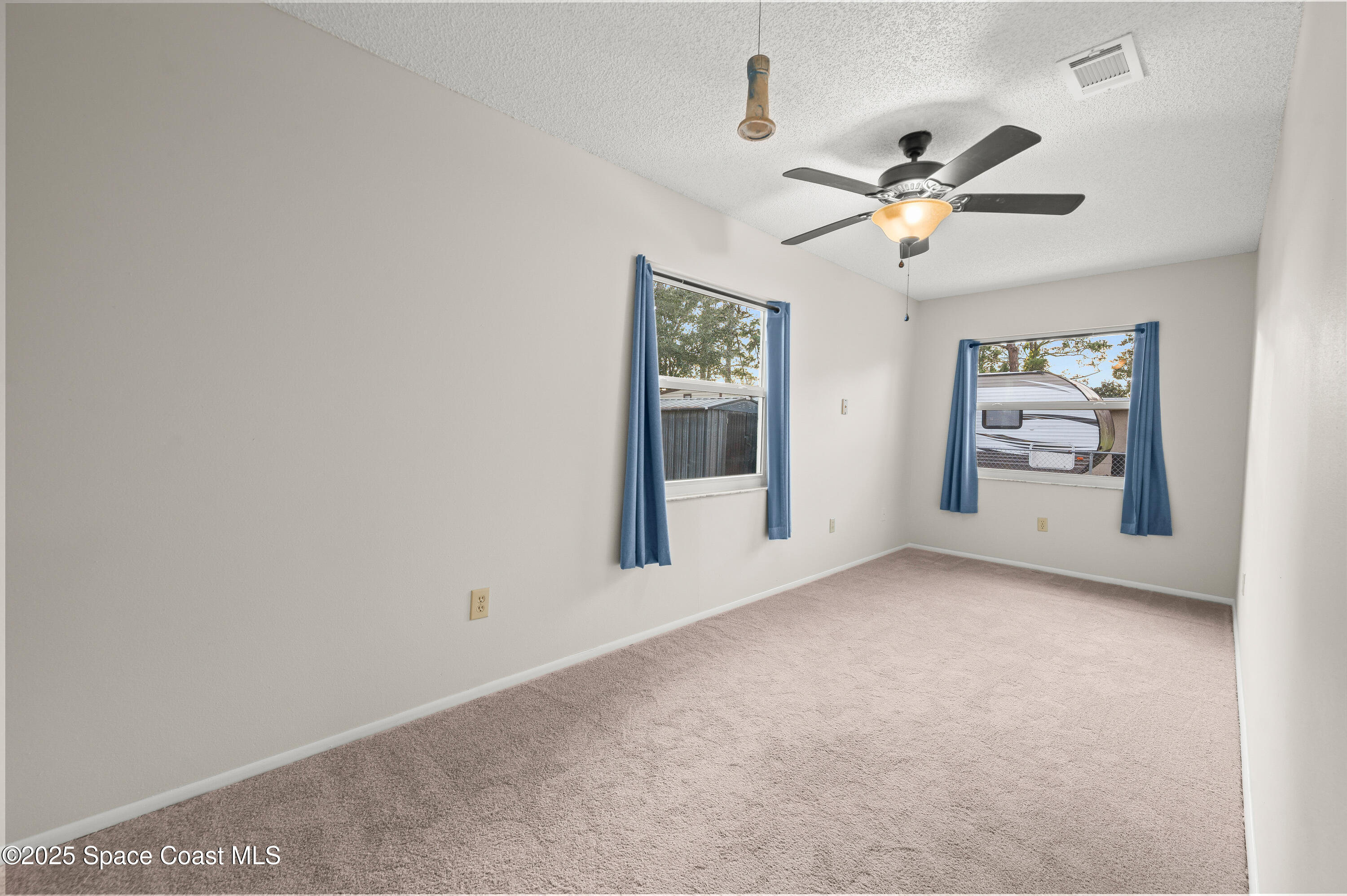 6450 Ember Avenue Cocoa, FL 32927 - Photo 27 of 40 an empty room with windows and fan