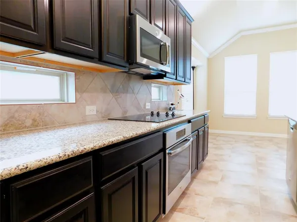 a kitchen with stainless steel appliances granite countertop a sink stove and microwave