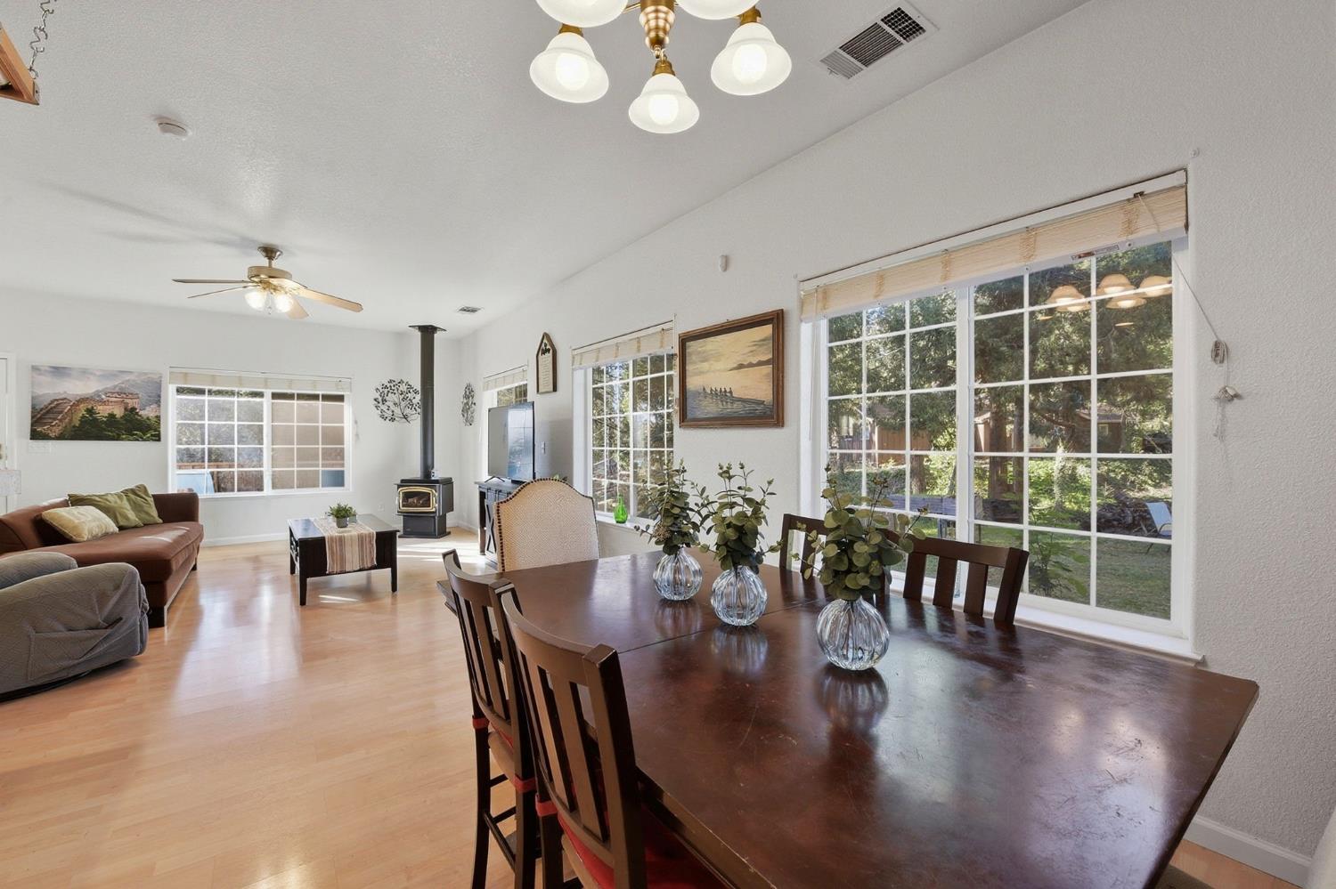 2845 Viona Road Pollock Pines, CA 95726 - Photo 11 of 35 a dining room with wooden floor a chandelier a glass table and chairs