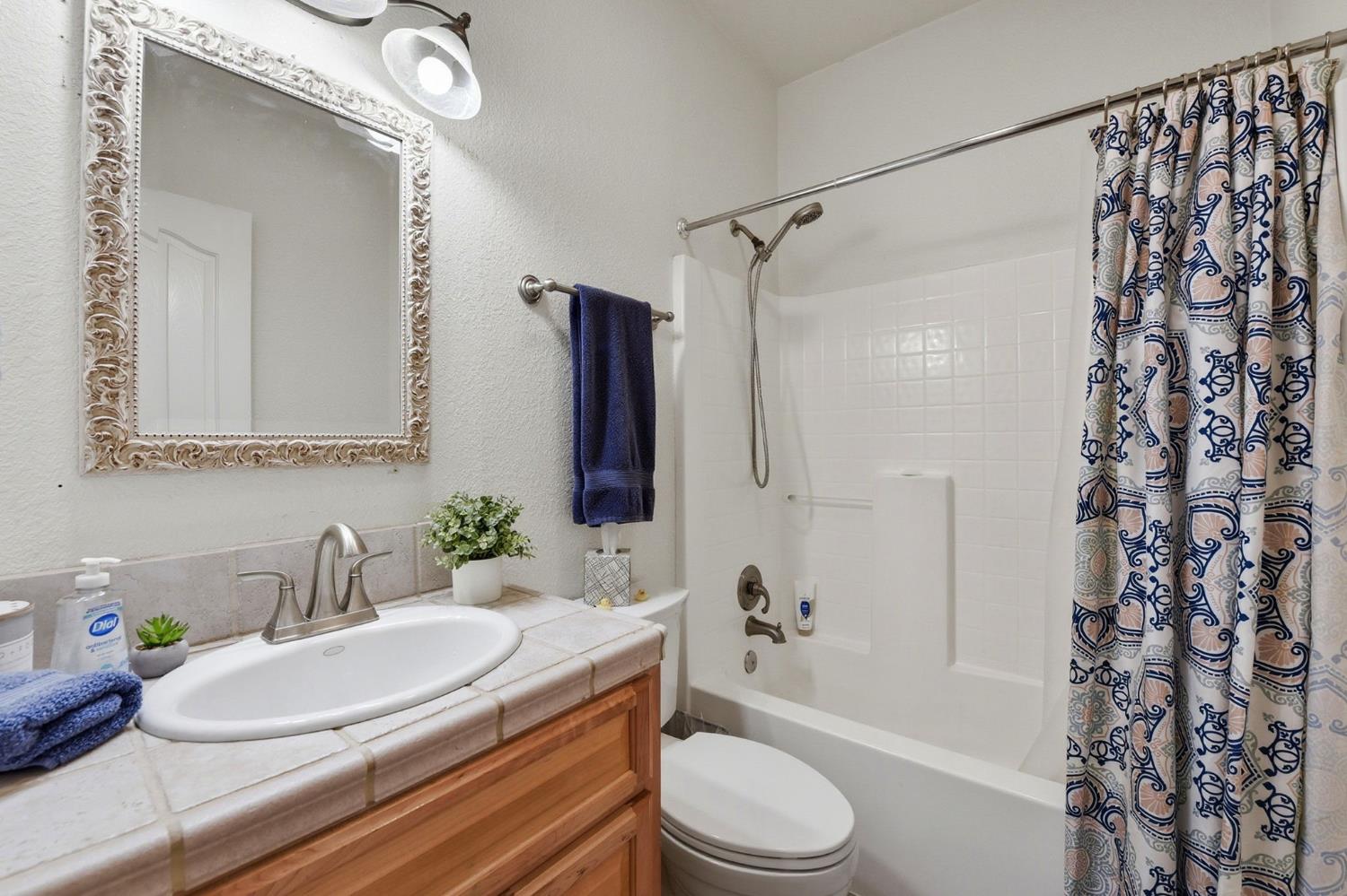 2845 Viona Road Pollock Pines, CA 95726 - Photo 23 of 32 a bathroom with a granite countertop sink toilet a mirror a bathtub and shower