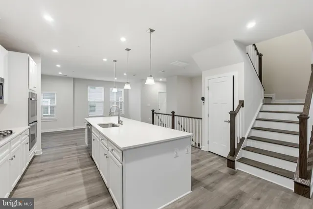 a large white kitchen with a sink a refrigerator and a stove