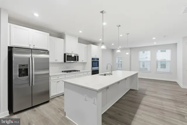 a large kitchen with kitchen island a sink stainless steel appliances and cabinets