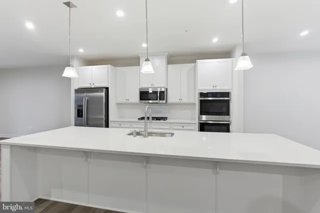 a kitchen with kitchen island white cabinets and stainless steel appliances