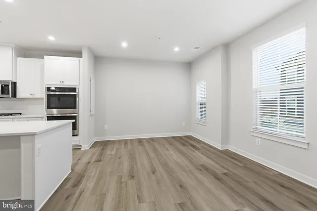 a view of kitchen with wooden floor and electronic appliances