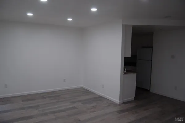 a view of a room with wooden floor and white walls