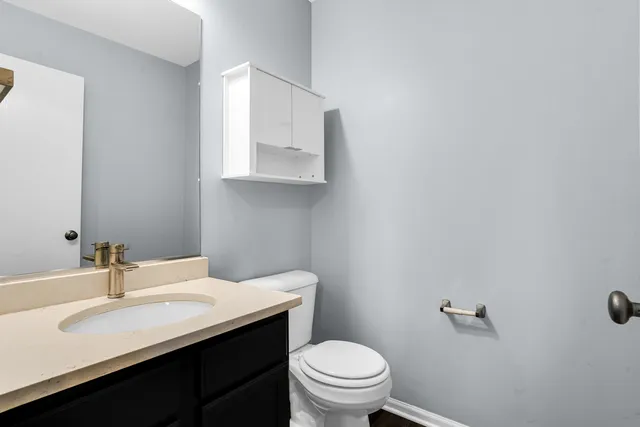 a bathroom with a sink vanity mirror and toilet