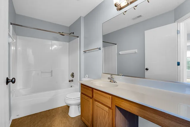 a bathroom with a bathtub shower sink vanity and toilet