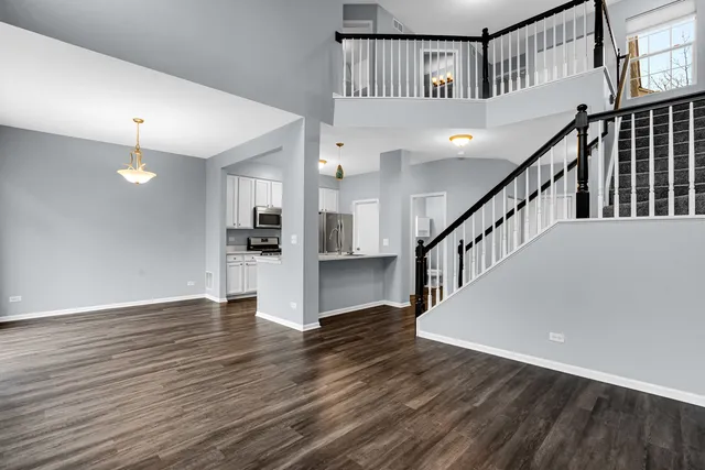a view of staircase with wooden floor and a chandelier