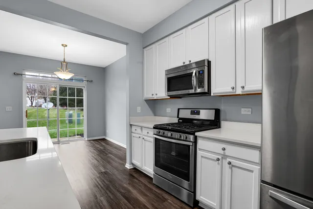 a kitchen with granite countertop a stove and a wooden floors