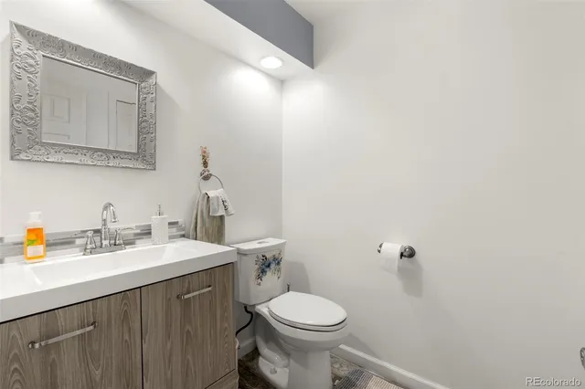 a bathroom with a sink vanity mirror and toilet