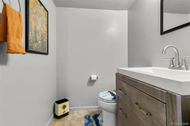 a bathroom with a toilet sink vanity and mirror