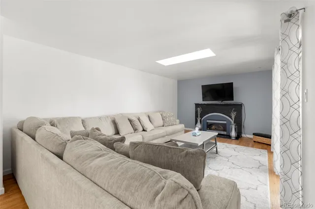 a living room with furniture a flat screen tv and a fireplace