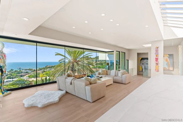 a large white kitchen with a large window and stainless steel appliances