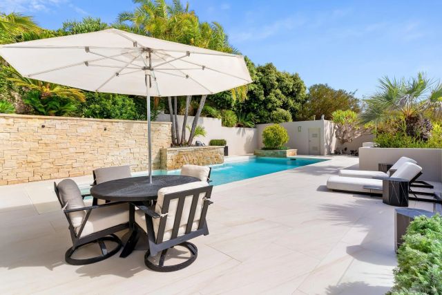 a living room with furniture kitchen view and a large window