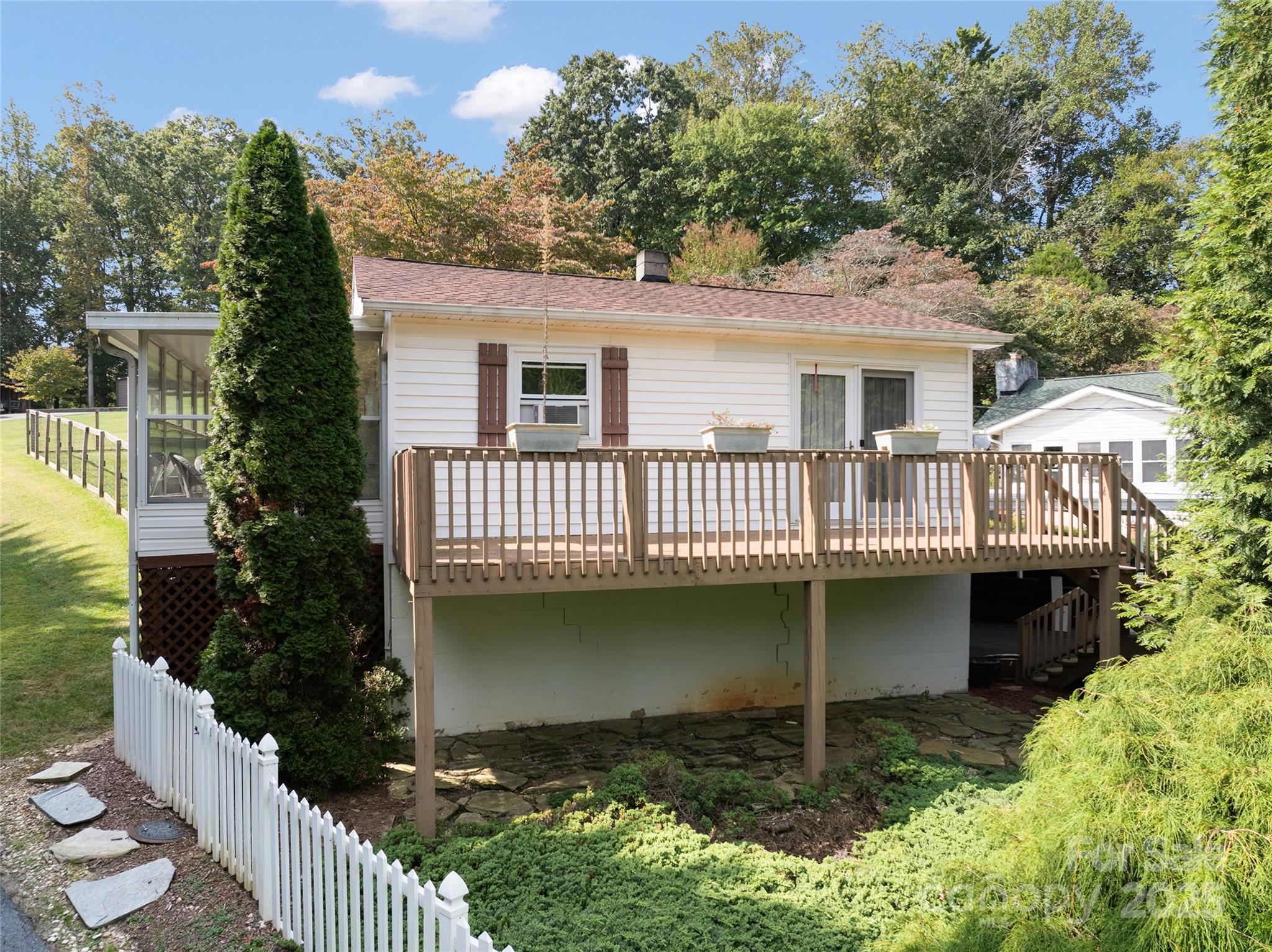 338 Morgan Road Candler, NC 28715 - Photo 28 of 42 a view of a house with wooden deck and a garden