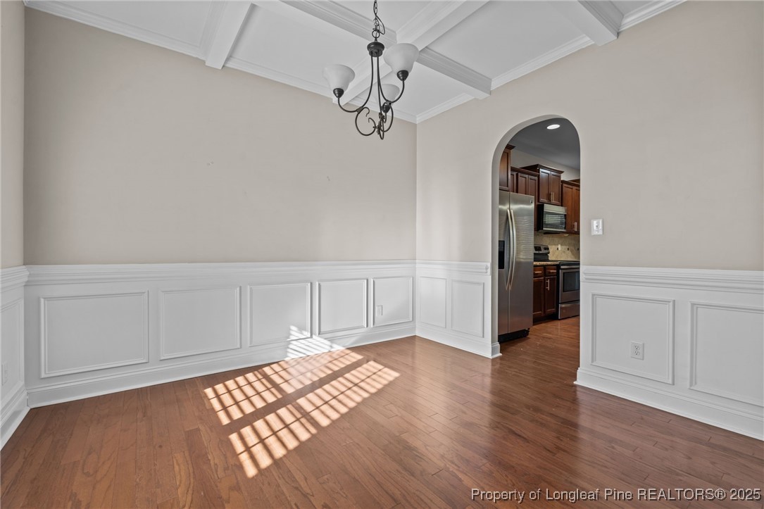 419 Rolling Pines Drive Spring Lake, NC 28390 - Photo 3 of 31 an empty room with wooden floor chandelier fan and windows