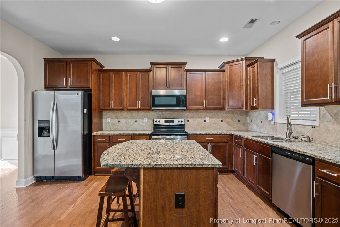 419 Rolling Pines Drive Spring Lake, NC 28390 - Photo 6 of 31 a kitchen with stainless steel appliances granite countertop a sink stove and refrigerator