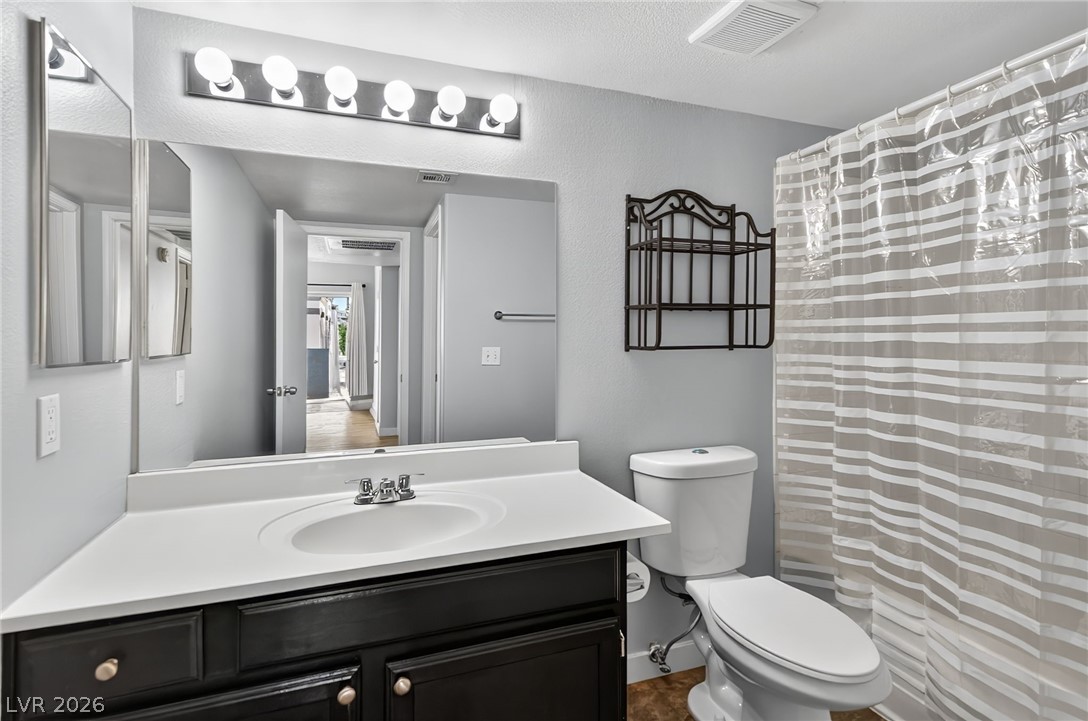 7255 West Sunset Road, Unit 2144 Las Vegas, NV 89113 - Photo 10 of 23 Bathroom featuring vanity, curtained shower, and a textured wall